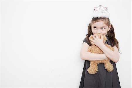 Girl wearing tiara holding teddy bear Stock Photo - Premium Royalty-Free, Code: 614-08030853