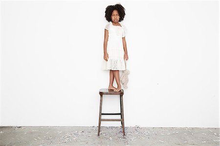 Girl standing on stool sulking and holding teddy bear Foto de stock - Sin royalties Premium, Código: 614-08030872