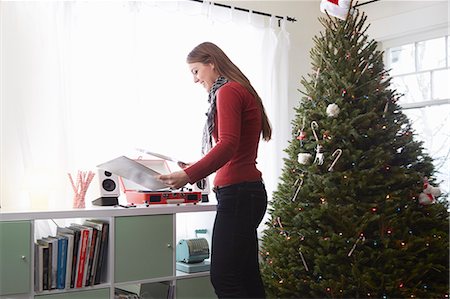 retro woman with christmas - Young woman putting vinyl on record player at christmas Stock Photo - Premium Royalty-Free, Code: 614-08030887