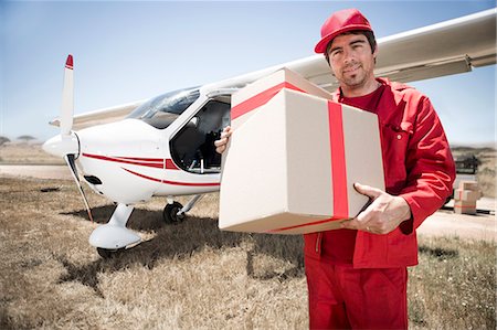 delivery man delivering boxes - Delivery man carrying parcel off airplane, Wellington, Western Cape, South Africa Stock Photo - Premium Royalty-Free, Code: 614-08030917