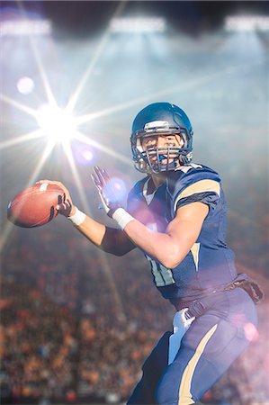 football skill - Teenage american footballer holding up ball in stadium Stock Photo - Premium Royalty-Free, Code: 614-08031107