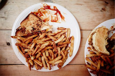 fast food plates - Unfinished sandwich, burger and french fries Stock Photo - Premium Royalty-Free, Code: 614-08031111