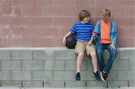 Two boys sitting on wall Stock Photo - Premium Royalty-Free, Code: 614-08031146