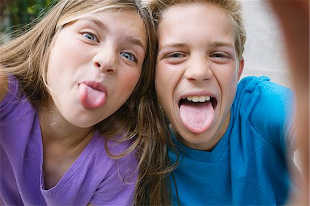 sacando la lengua - Girl and boy sticking out tongues Foto de stock - Sin royalties Premium, Código: 614-08031170