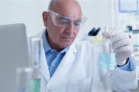 Senior male scientist looking at flask, containing blue liquid Photographie de stock - Premium Libres de Droits, Code: 614-08065880