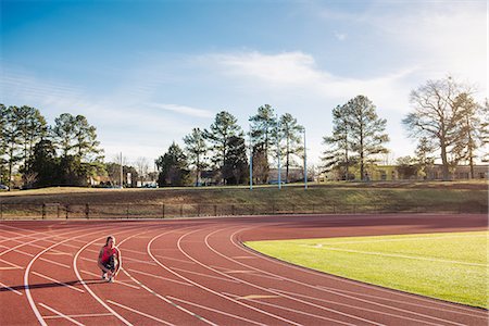 simsearch:614-07234799,k - Young female athlete tying trainer laces on race track Foto de stock - Sin royalties Premium, Código: 614-08065915