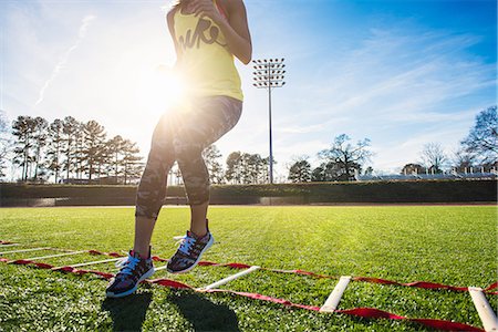 Neck down view of female athlete training with agility ladder on sports field Stock Photo - Premium Royalty-Free, Code: 614-08065926