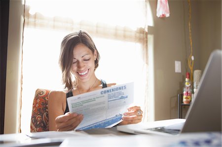 Woman working at desk at home reading paperwork Photographie de stock - Premium Libres de Droits, Code: 614-08065958