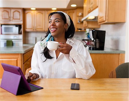 simsearch:614-06169479,k - Young woman using digital tablet at kitchen table Stock Photo - Premium Royalty-Free, Code: 614-08065972