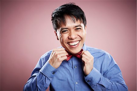 simsearch:614-02679072,k - Portrait of mid adult man, adjusting bow tie, smiling Stock Photo - Premium Royalty-Free, Code: 614-08066042