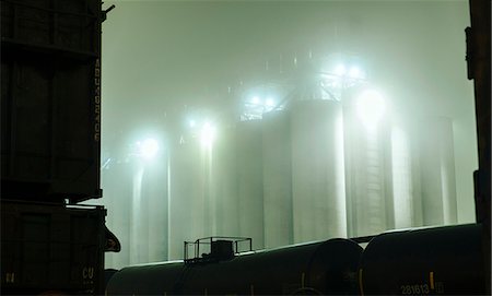 Misty view of industrial storage tanks between locomotive at night, Seattle, Washington, USA Stock Photo - Premium Royalty-Free, Code: 614-08066145