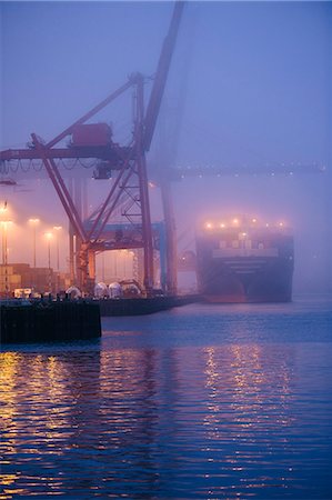 Misty view of cargo ship and cranes on waterfront at night, Seattle, Washington, USA Stock Photo - Premium Royalty-Free, Code: 614-08066147