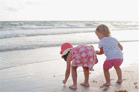 Siblings exploring on the beach at sunset Foto de stock - Sin royalties Premium, Código: 614-08066185