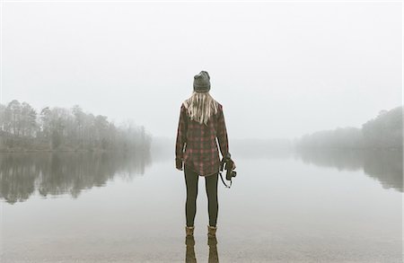 eskapismus - Young woman with camera standing in misty lake Photographie de stock - Premium Libres de Droits, Code: 614-08081228