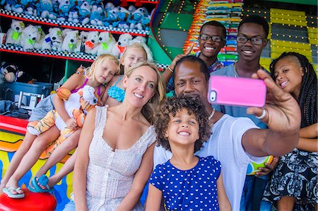Family taking smartphone selfie at amusement park Stock Photo - Premium Royalty-Free, Code: 614-08081234