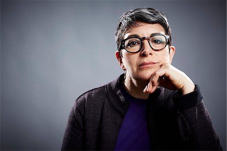 Studio portrait of mature businesswoman with chin on hand Foto de stock - Sin royalties Premium, Código: 614-08081361