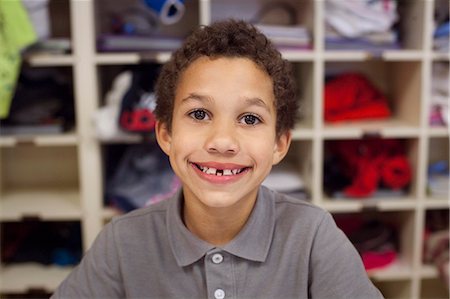 Boy with wide smile, shelves in background Foto de stock - Sin royalties Premium, Código: 614-08081403