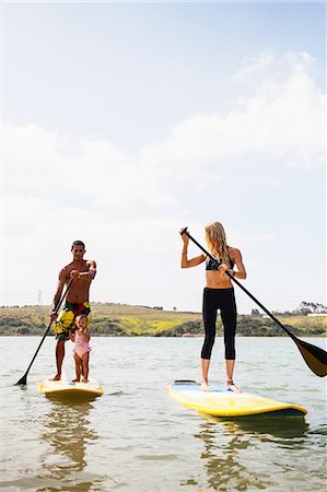 parent teaching toddler - Couple and toddler daughter standup paddleboarding, Carlsbad, California, USA Stock Photo - Premium Royalty-Free, Code: 614-08119469