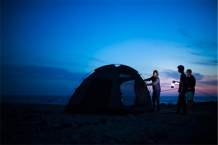 simsearch:614-08119609,k - Group of friends setting up tent on beach at sunset Foto de stock - Sin royalties Premium, Código: 614-08119616