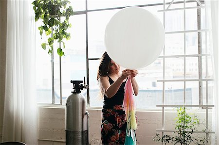 simsearch:614-08119665,k - Young woman attaching bunting to balloon in design studio Fotografie stock - Premium Royalty-Free, Codice: 614-08119663