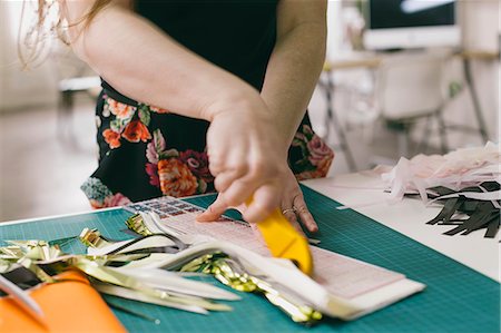 Close up of female textile designer cutting textiles in design studio Foto de stock - Sin royalties Premium, Código: 614-08119674