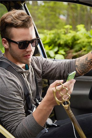 simsearch:614-08119697,k - Portrait of man driving wearing sunglasses and using smart phone Fotografie stock - Premium Royalty-Free, Codice: 614-08119710