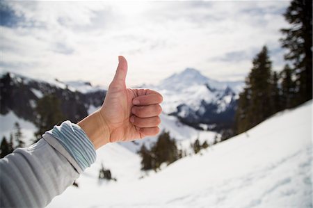 Female hand making thumbs up in front of snow covered view, Mount Baker, Washington, USA Foto de stock - Royalty Free Premium, Número: 614-08119787