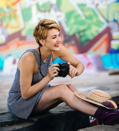 simsearch:614-06895809,k - Stylish teenage girl sitting on sidewalk with camera in front of graffiti wall Stock Photo - Premium Royalty-Free, Code: 614-08119783