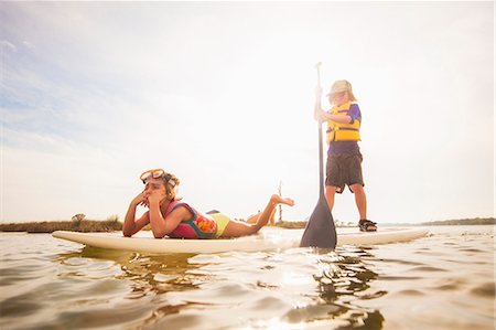 Boy standup paddleboarding with sister in the sound, Fort Walton, Florida, USA Foto de stock - Sin royalties Premium, Código: 614-08119790