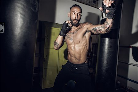 Poised male boxer with bandaged hands in gym Foto de stock - Sin royalties Premium, Código: 614-08119884