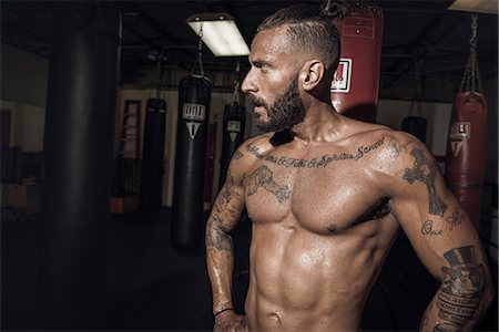 sweaty man - Portrait of tattooed male boxer with hands on hips in gym Stock Photo - Premium Royalty-Free, Code: 614-08119892