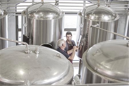 Brewers in brewery next to stainless steel tanks Stock Photo - Premium Royalty-Free, Code: 614-08119904
