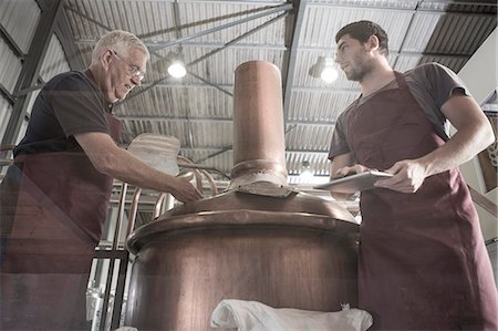 food factory - Brewers looking into brewing machine Photographie de stock - Premium Libres de Droits, Code: 614-08119912