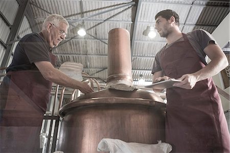 food manufacture - Brewers looking into brewing machine Photographie de stock - Premium Libres de Droits, Code: 614-08119912