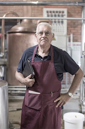 Portrait of brewer in brewery, standing next to stainless steel tanks Foto de stock - Sin royalties Premium, Código: 614-08119927