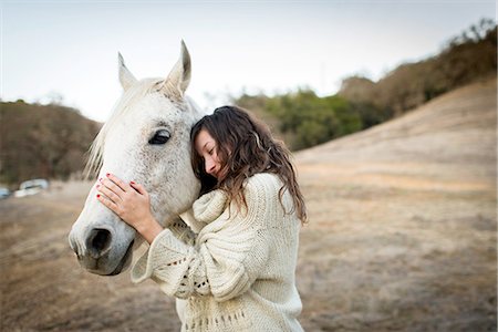 simsearch:649-08125934,k - Young woman leaning against and petting white horse in field Stock Photo - Premium Royalty-Free, Code: 614-08126663