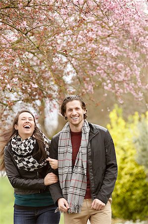 Young couple strolling and laughing in park Stock Photo - Premium Royalty-Free, Code: 614-08126757