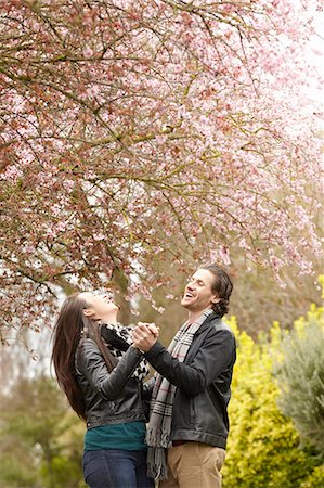 Young couple dancing under blossom in park Stock Photo - Premium Royalty-Free, Code: 614-08126759