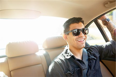 Smiling young man in back seat of car Stock Photo - Premium Royalty-Free, Code: 614-08126769