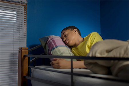 Teenage boy asleep in bunkbed Fotografie stock - Premium Royalty-Free, Codice: 614-08126784