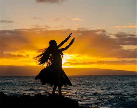 ethnic costume - Silhouetted young woman in traditional costume, hula dancing on coastal rock at sunset, Maui, Hawaii, USA Stock Photo - Premium Royalty-Free, Code: 614-08126793