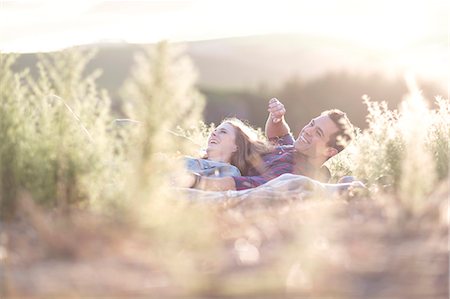 simsearch:614-08120049,k - Young couple lying together outdoors laughing Foto de stock - Sin royalties Premium, Código: 614-08120052