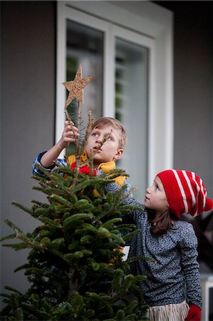 simsearch:614-07444164,k - Portrait of a boy and girl putting star decoration on top of christmas tree Stock Photo - Premium Royalty-Free, Code: 614-08120086