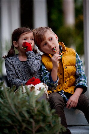 Portrait of a boy and girl eating festive candy canes Stock Photo - Premium Royalty-Free, Code: 614-08120087