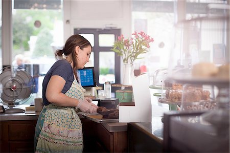 Bakery owner placing cake into box Stock Photo - Premium Royalty-Free, Code: 614-08148347