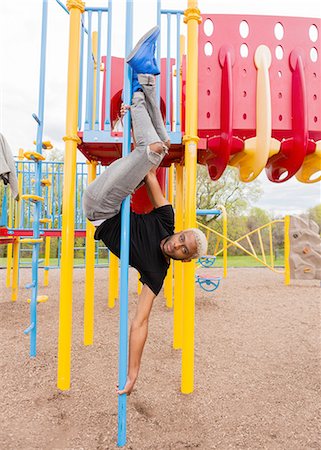 Young man upside down on pole in playground Photographie de stock - Premium Libres de Droits, Code: 614-08148415