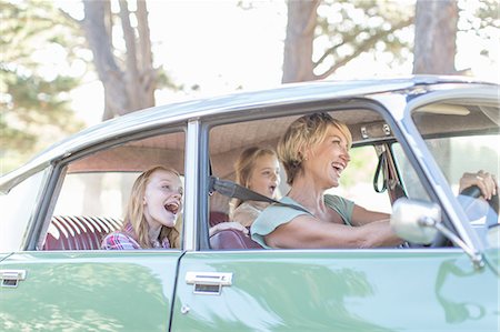 fun in car - Grandmother driving car, granddaughters sitting in back seat Stock Photo - Premium Royalty-Free, Code: 614-08148504