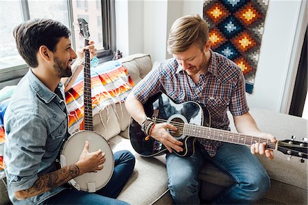 Male couple at home, play guitar and banjo, laughing Stock Photo - Premium Royalty-Free, Code: 614-08148666