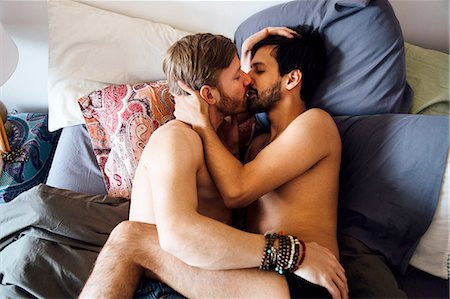 Male couple, partially dressed, lying on bed, kissing Foto de stock - Sin royalties Premium, Código: 614-08148672