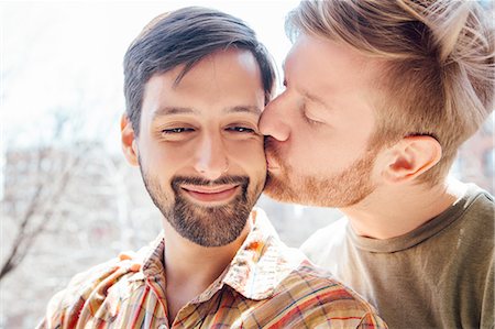 people home comfort adult - Portrait of male couple, mid adult man kissing his partner's cheek Stock Photo - Premium Royalty-Free, Code: 614-08148686